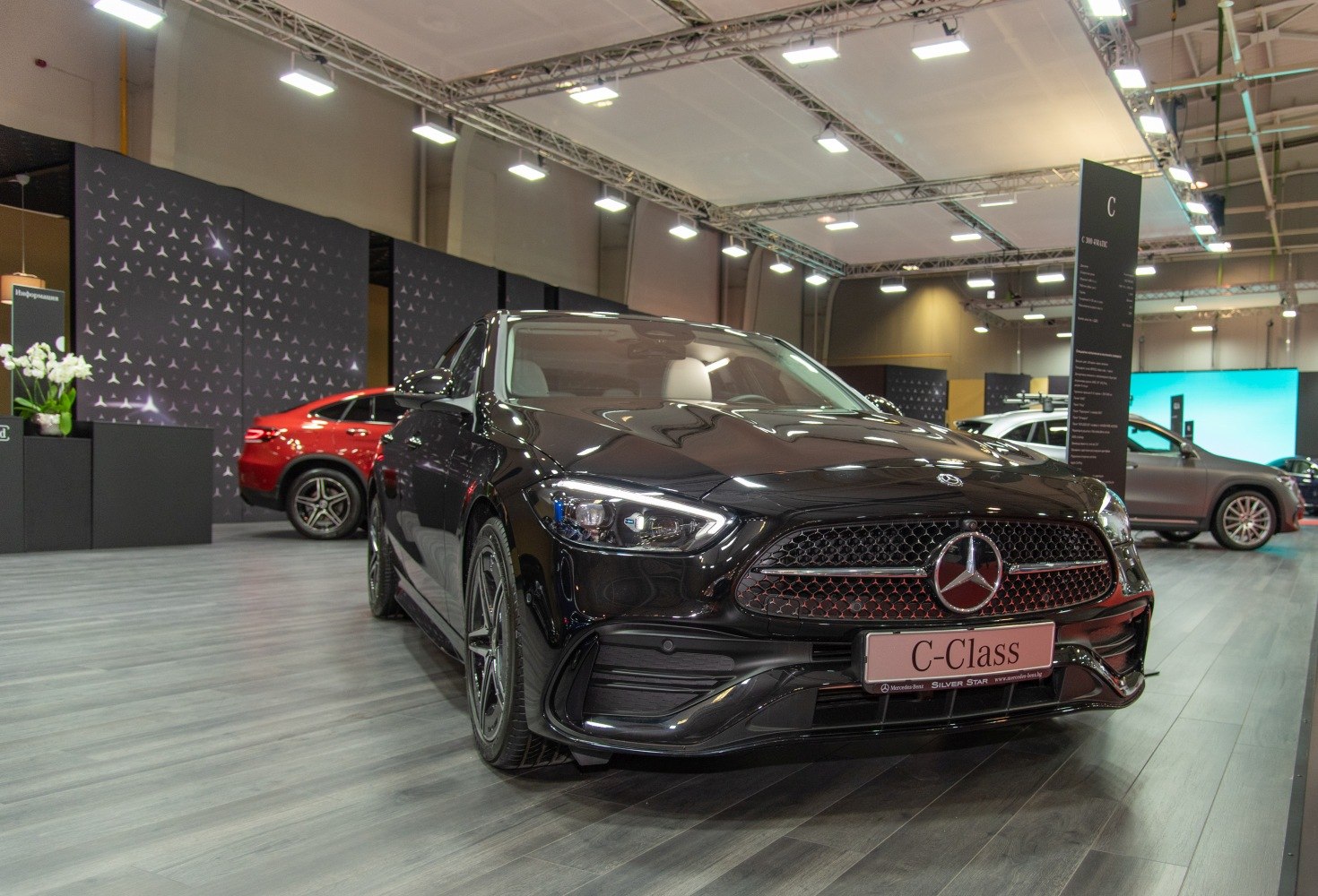 Front view of black luxury sedan with LED headlights and mesh grille