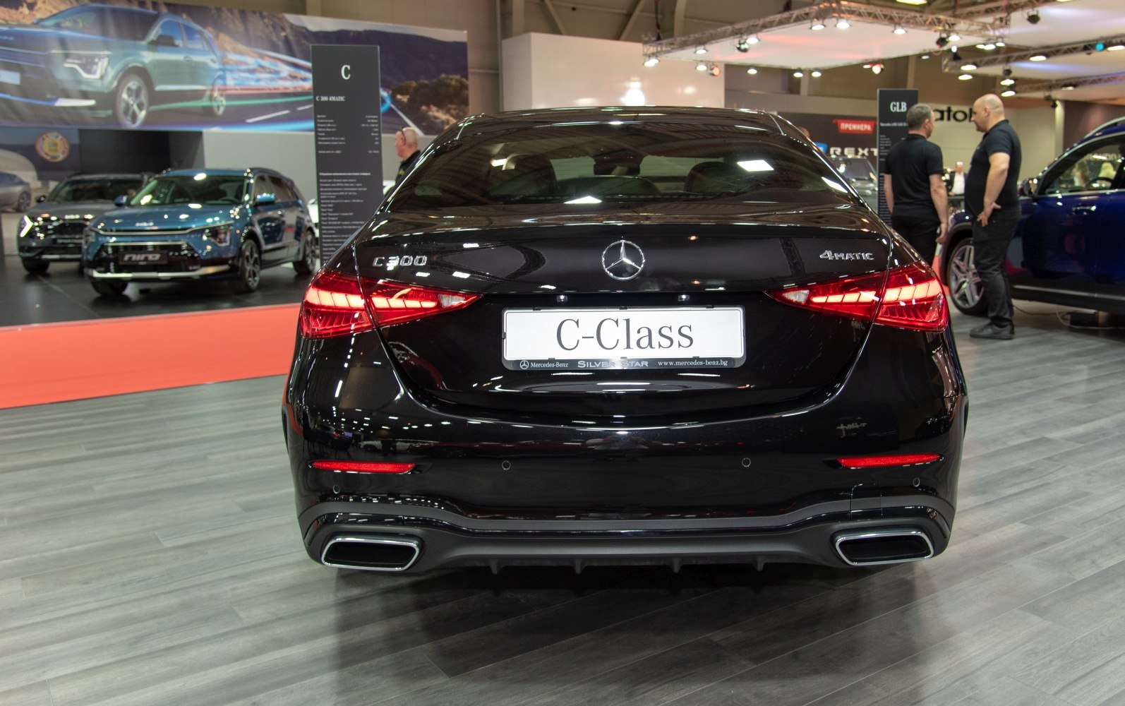 Rear view with C 200 and 4MATIC badges, distinctive tail lights, and dual exhausts.