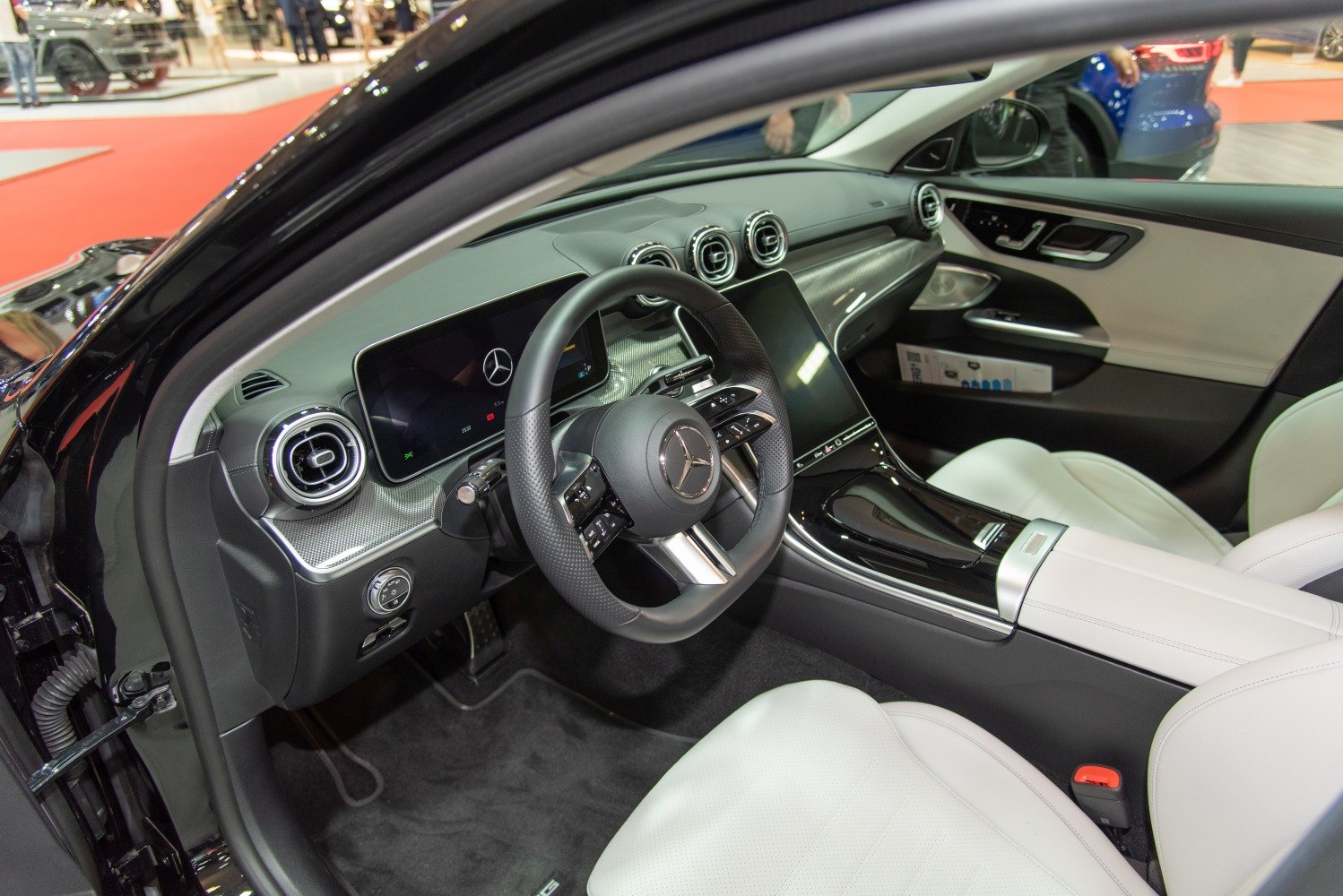 Modern luxury car interior with digital displays and white leather seats