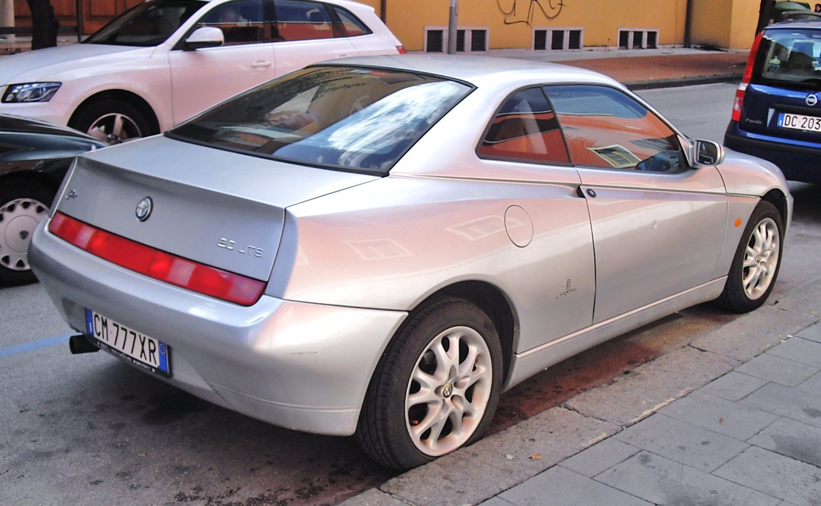 Rear and side view of a silver sports coupe with distinctive rear light bar.