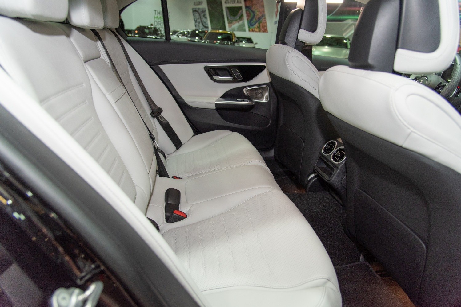 White leather rear passenger seats with ventilation vents and door panel details
