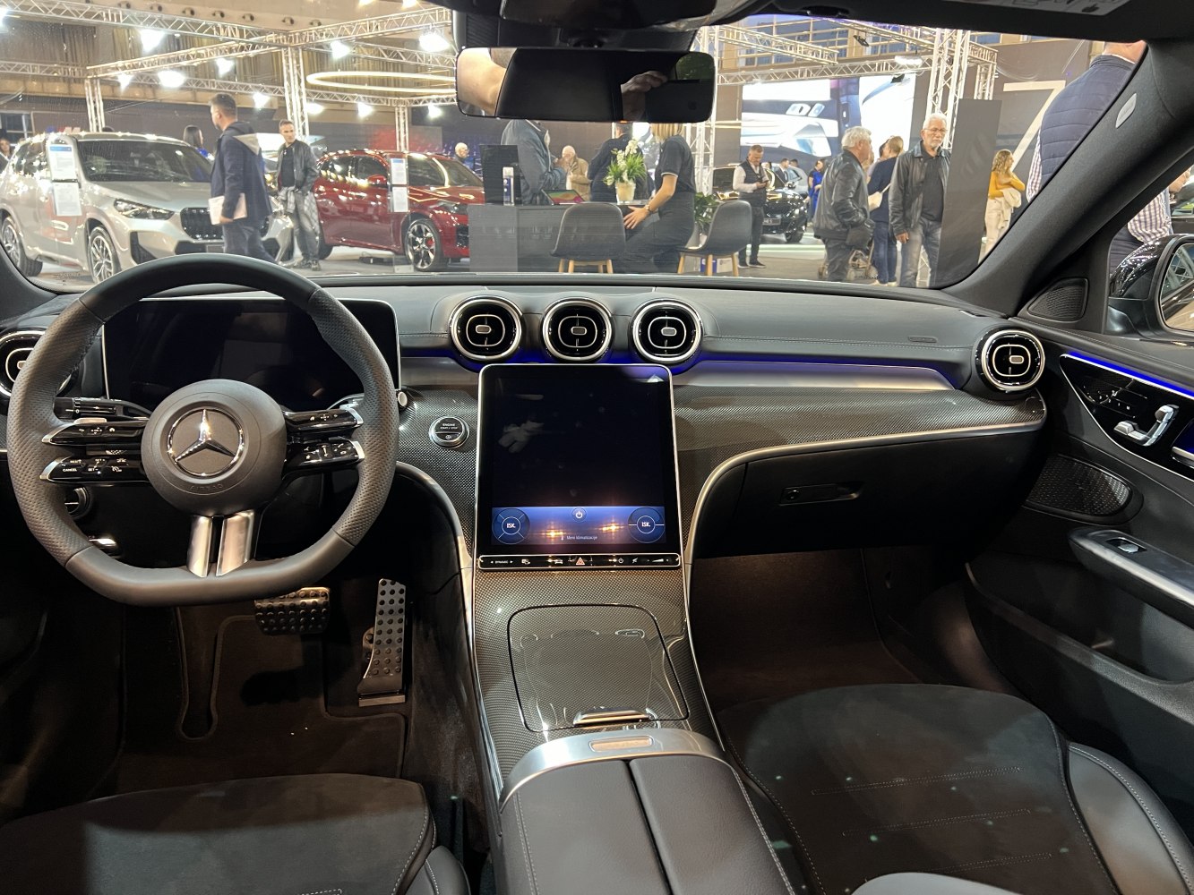 Modern Mercedes-Benz interior with touchscreen, ambient lighting, and digital controls