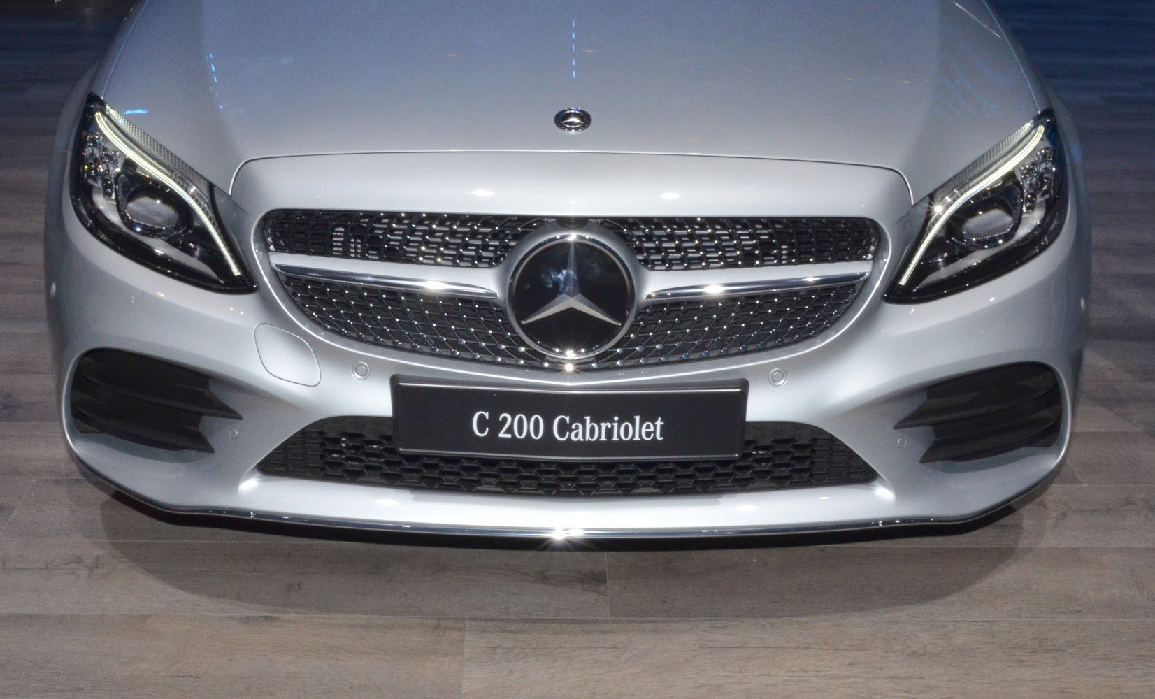 Close-up of front grille, headlights, and emblem of luxury cabriolet