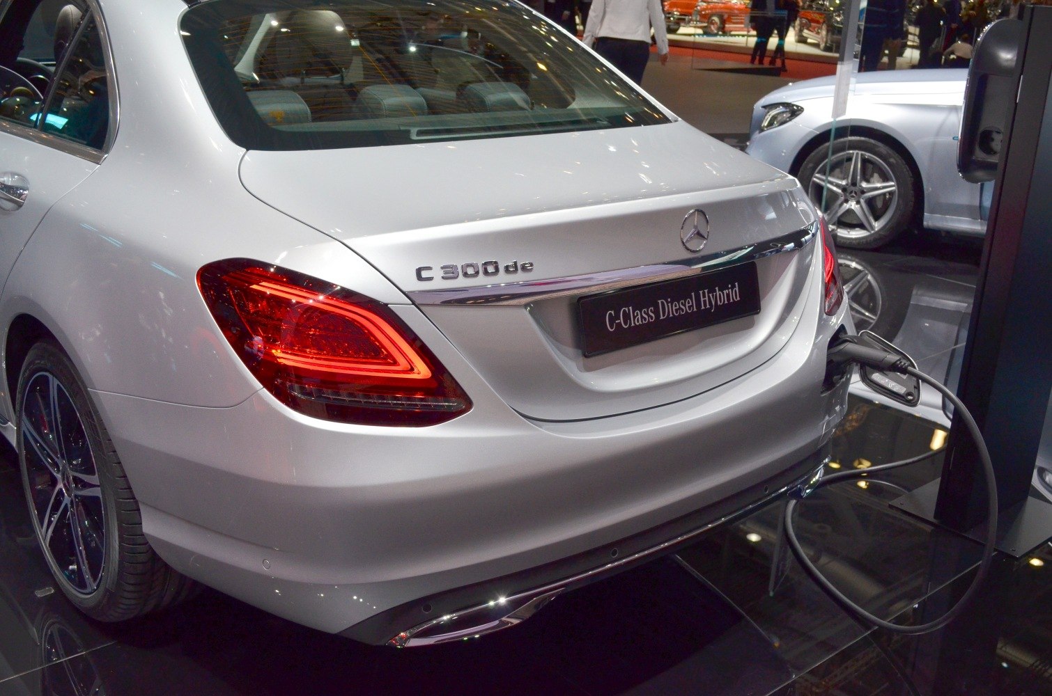 Rear view of silver diesel hybrid sedan with tail lights and charging cable