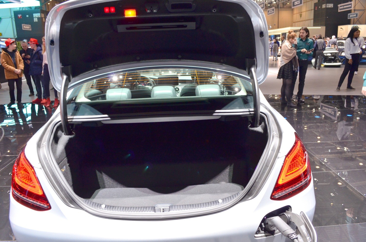 Open trunk and visible electric charging port of a luxury sedan
