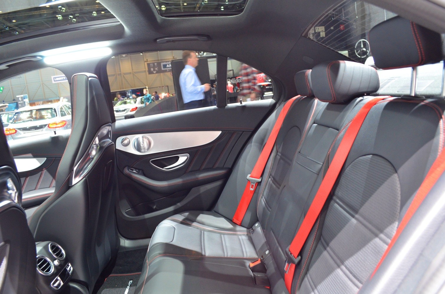 Rear seat interior with leather upholstery and red seat belts