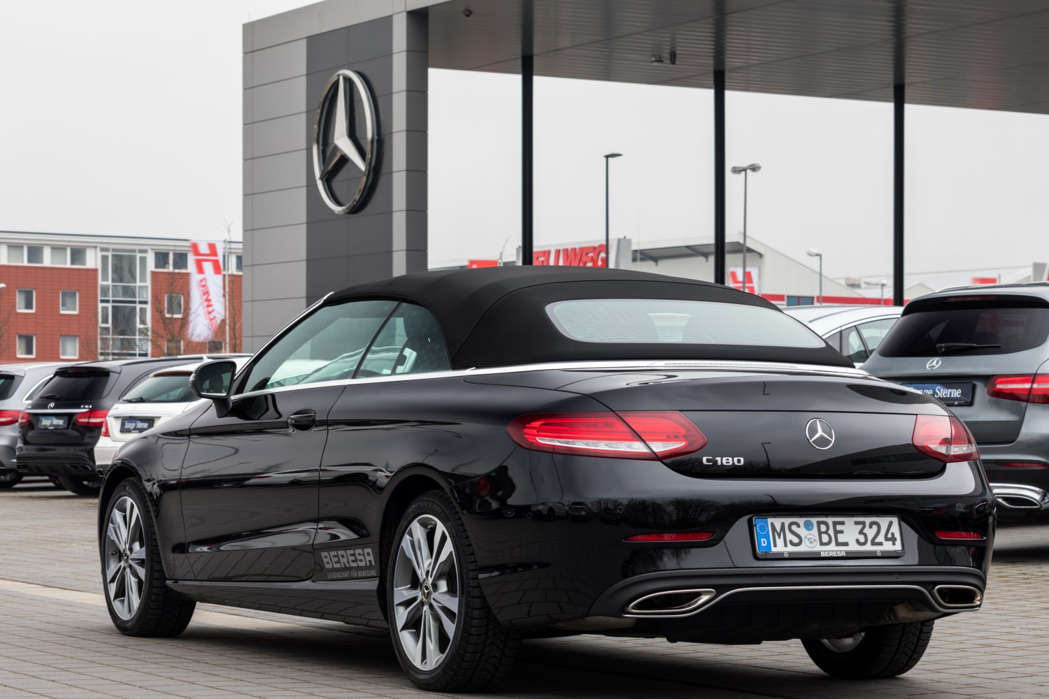 Luxury convertible with soft fabric roof and dual chrome exhaust tailpipes