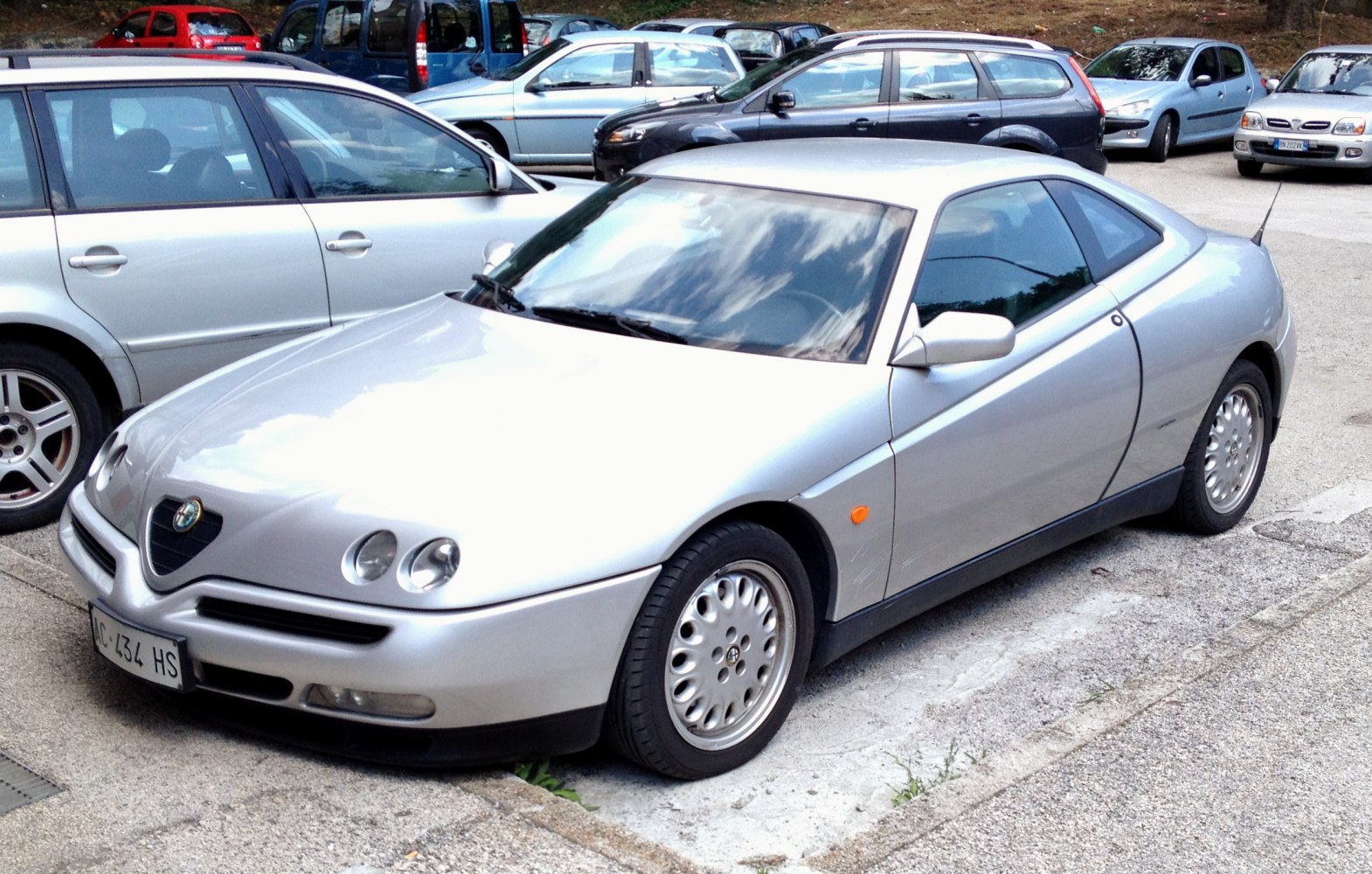 Silver coupe with round headlights and aerodynamic front side profile