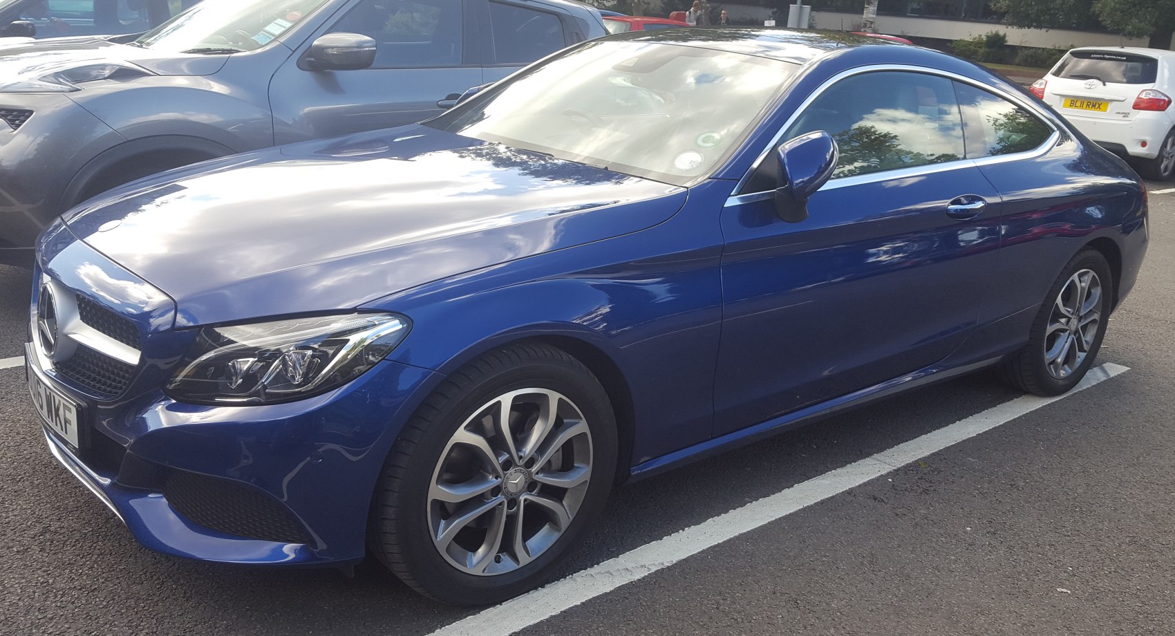 Luxury blue coupe with sleek LED headlights and aerodynamic body