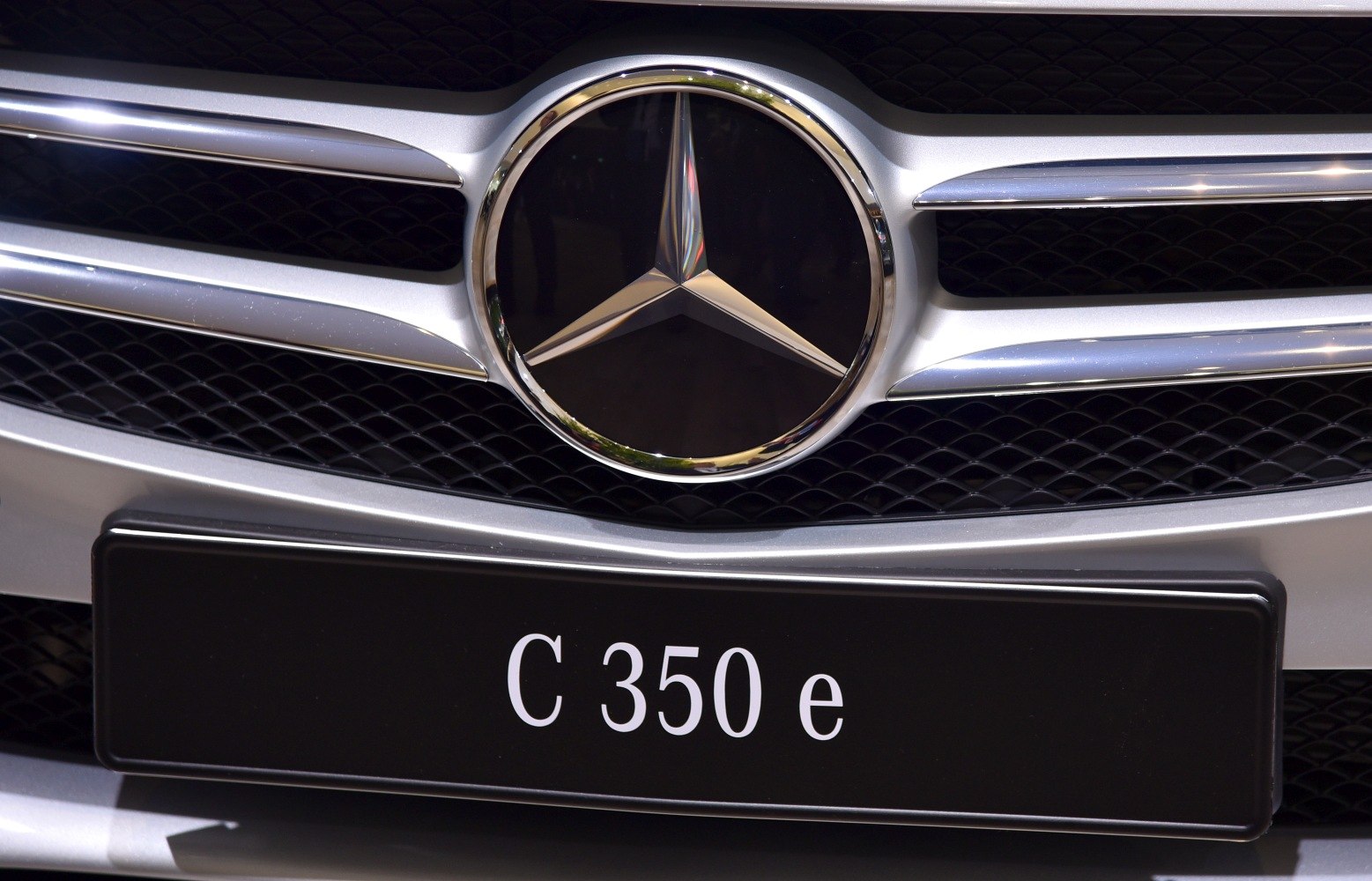 Close-up of car front grille with three-pointed star emblem and C 350 e plate