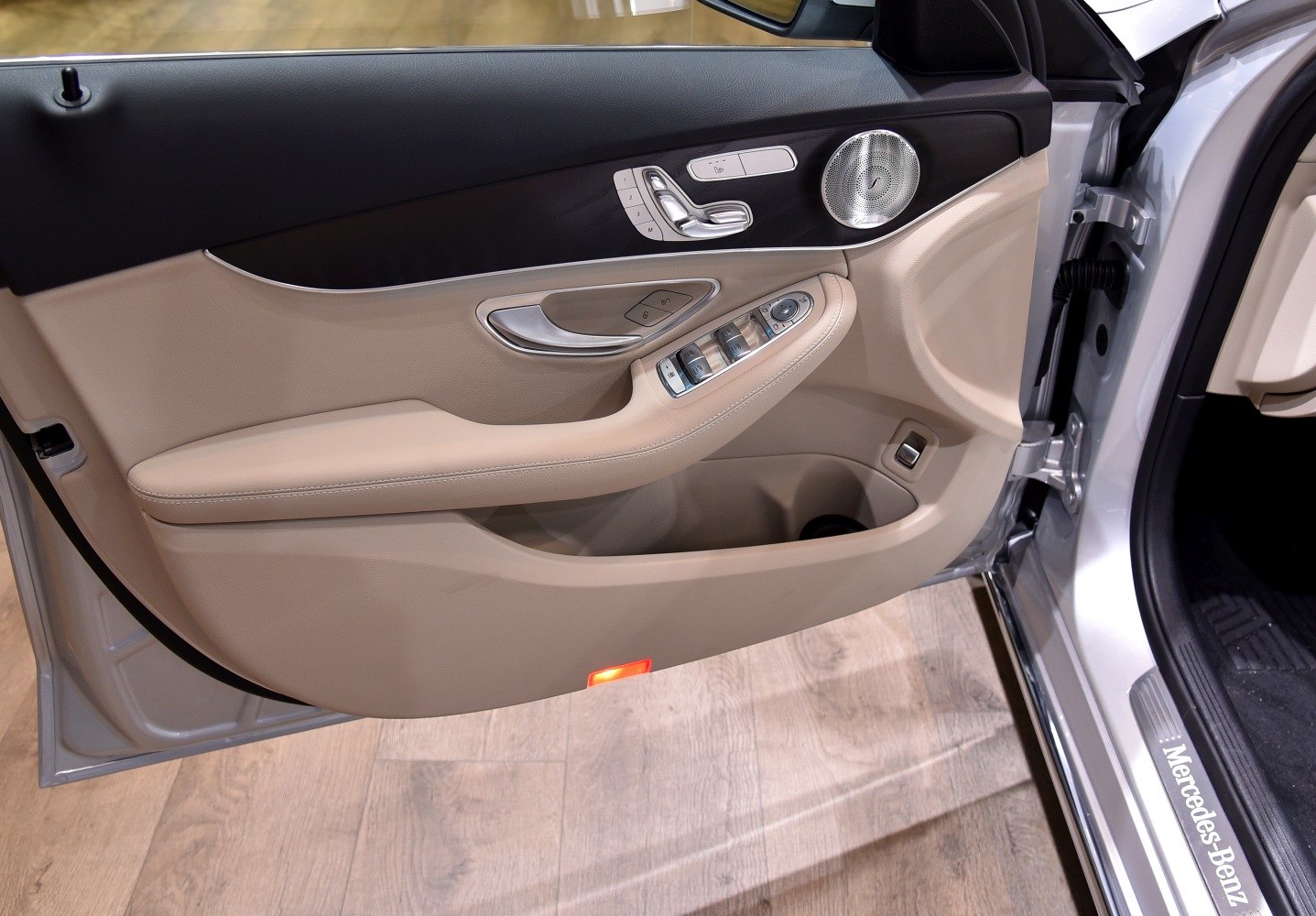 Luxury car interior door panel with controls and speaker grille