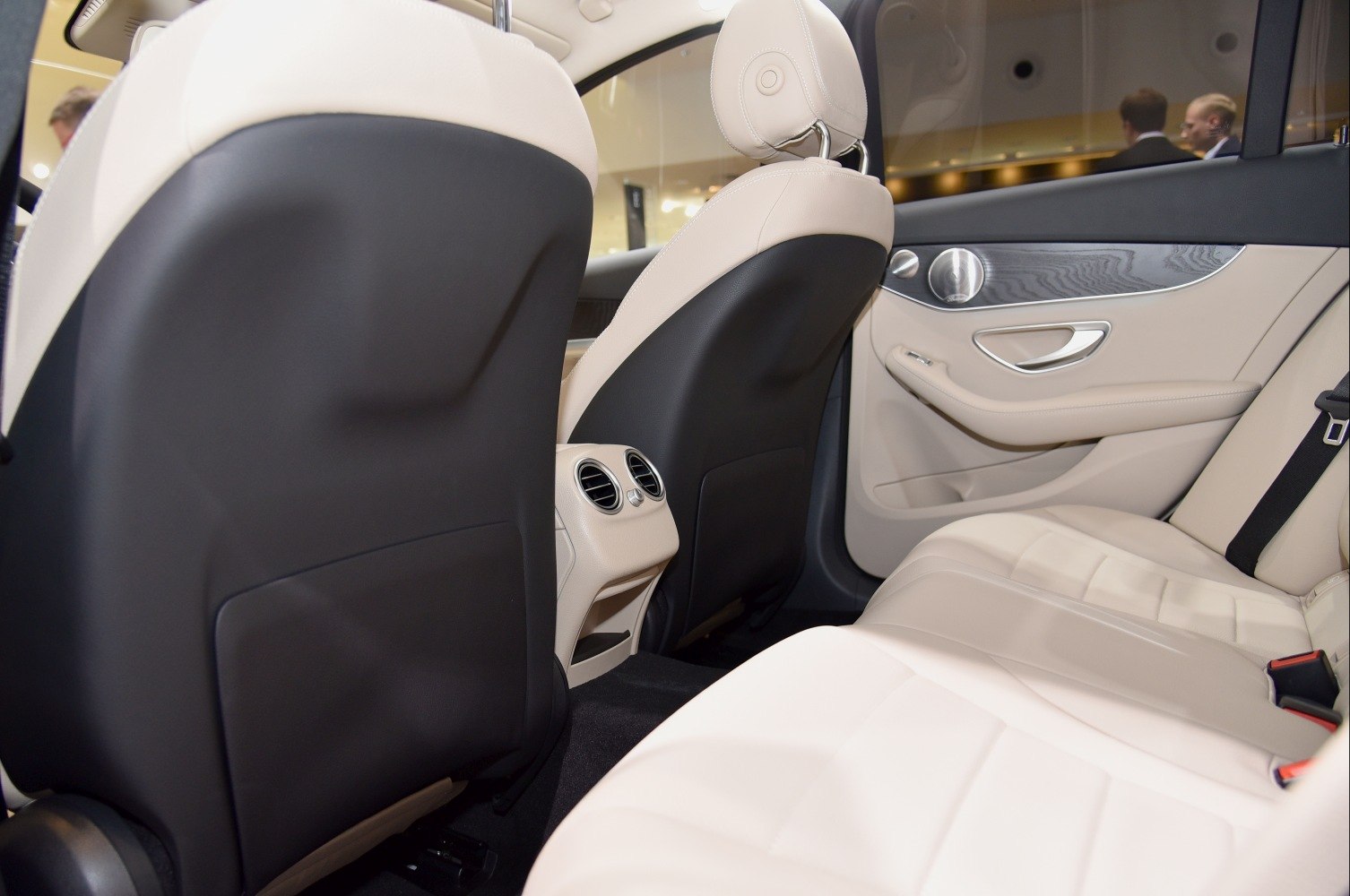 Beige leather rear seats with integrated air vents and black seat backs