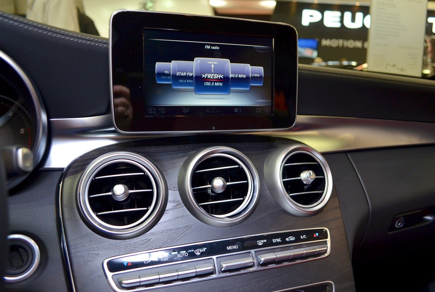 Central infotainment display and three circular air vents on dashboard