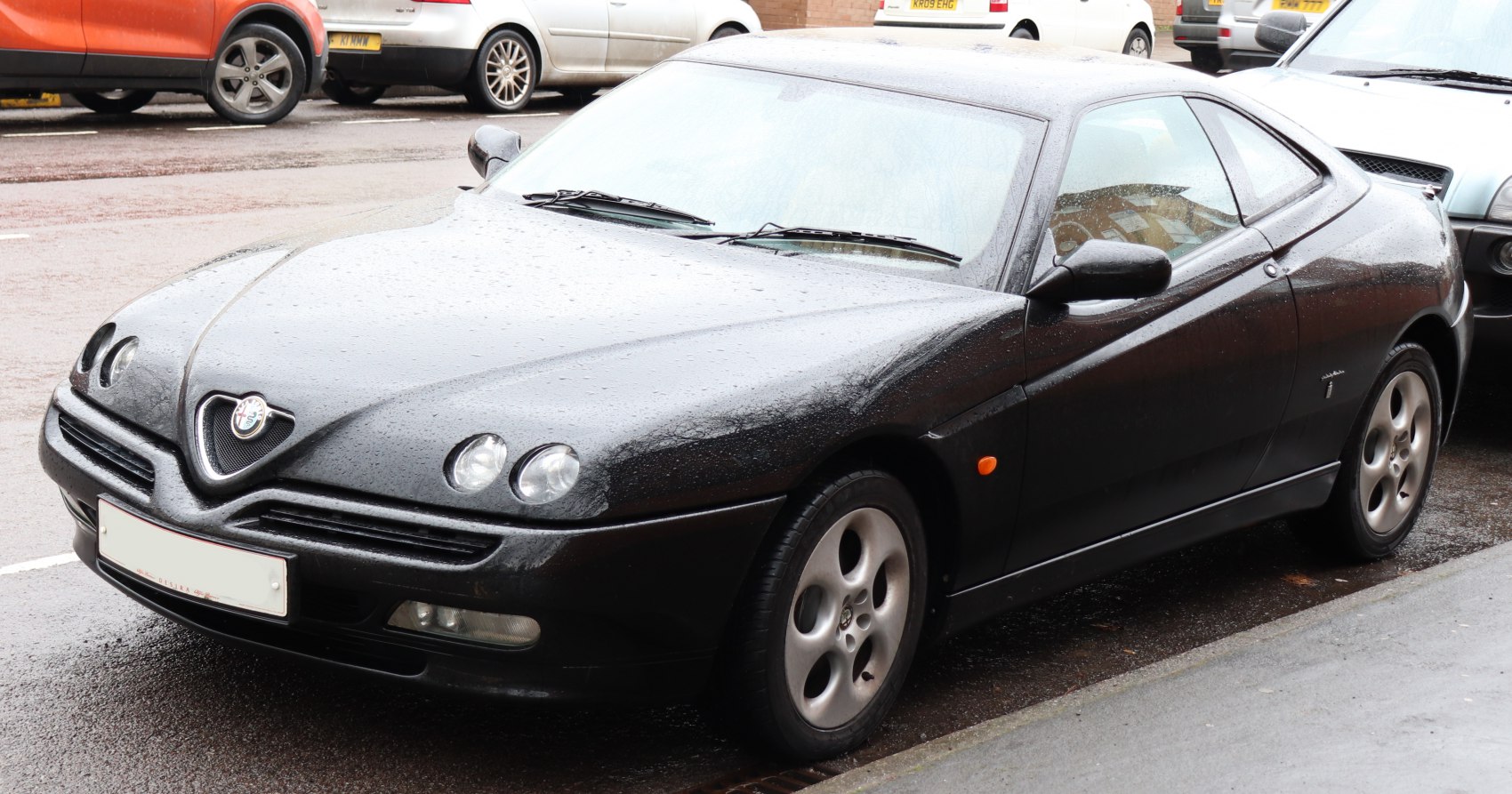 Twin round headlights and sleek aerodynamic black coupe