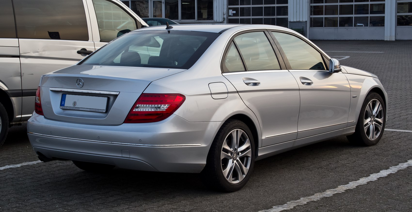 Rear side view of silver sedan with prominent taillights and alloy wheels