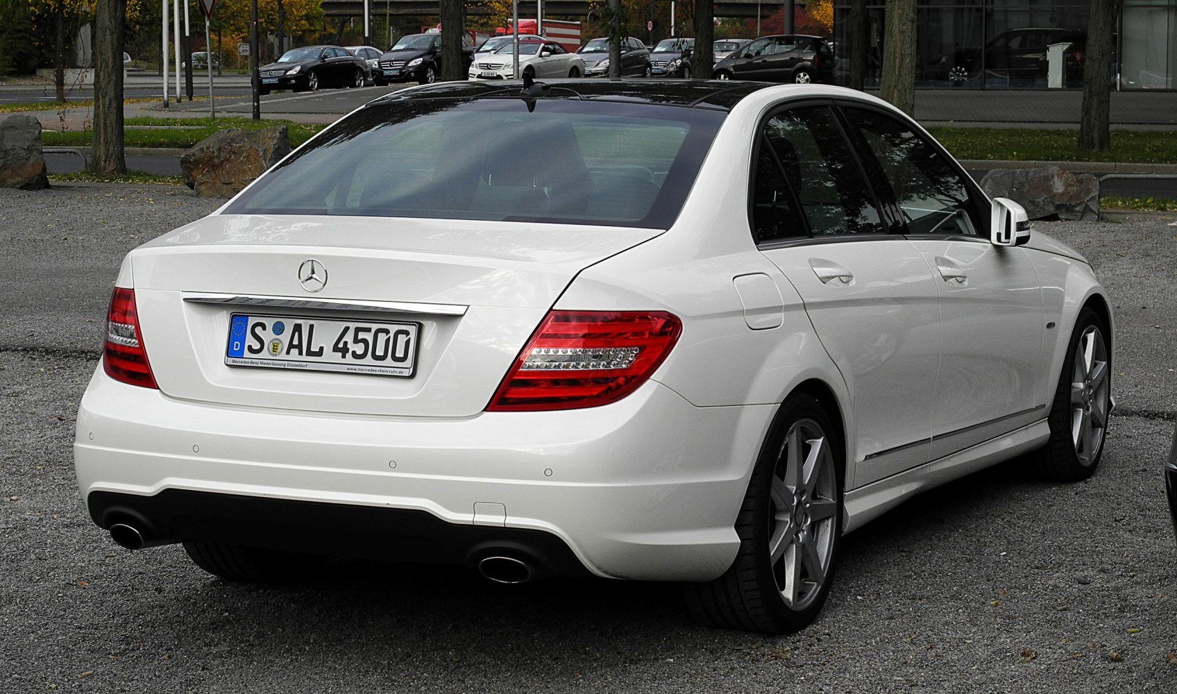 White sedan rear view with dual exhaust and LED taillights