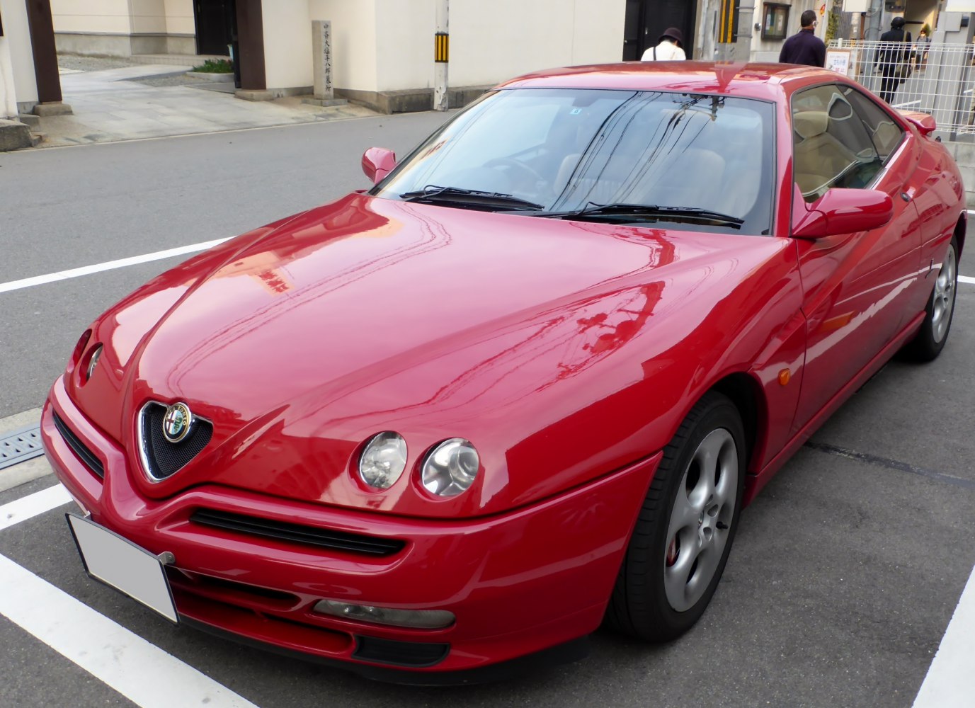Red coupe with dual round headlamps and aerodynamic front design