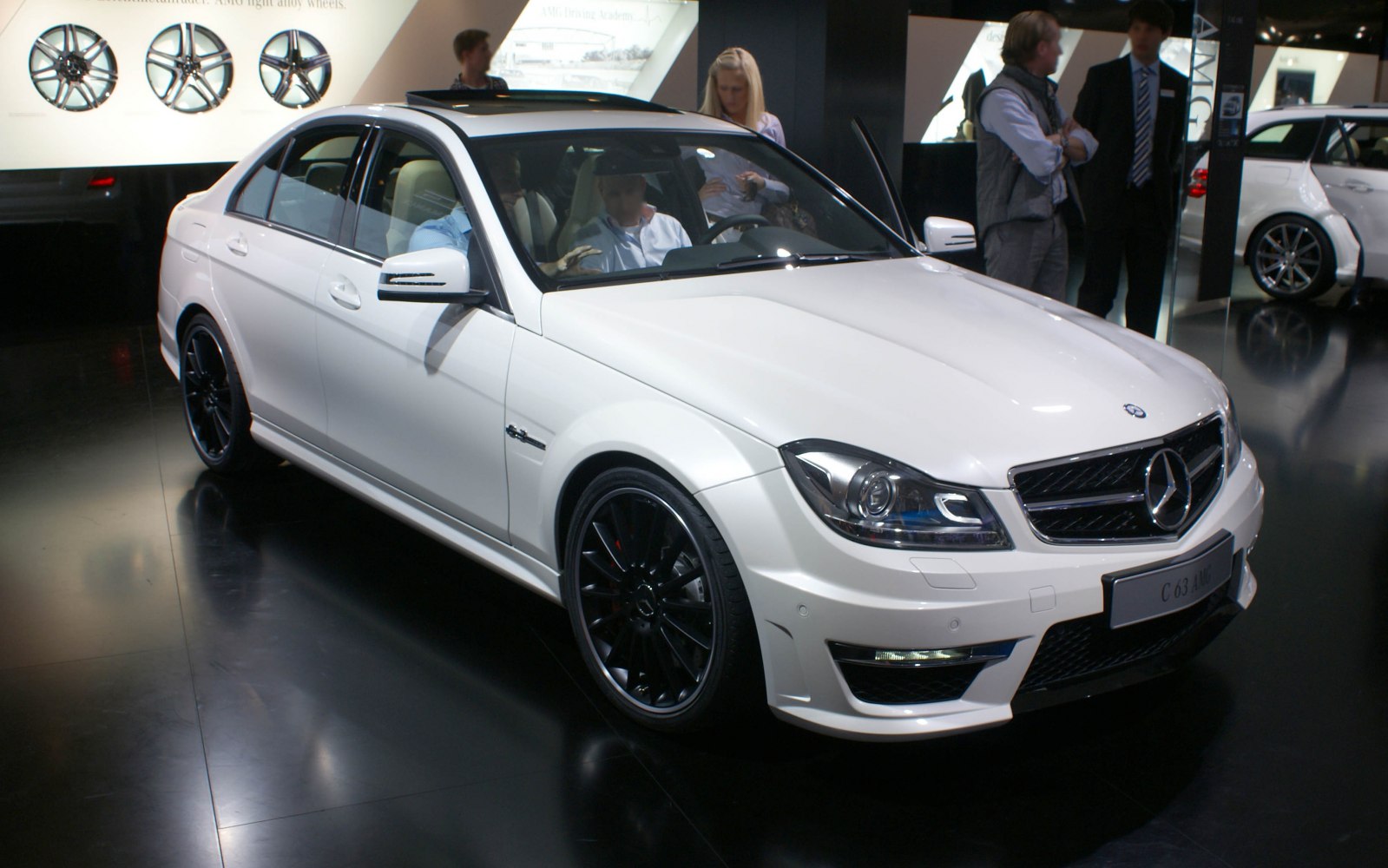 White sedan with black AMG multi-spoke alloy wheels and updated facelift design