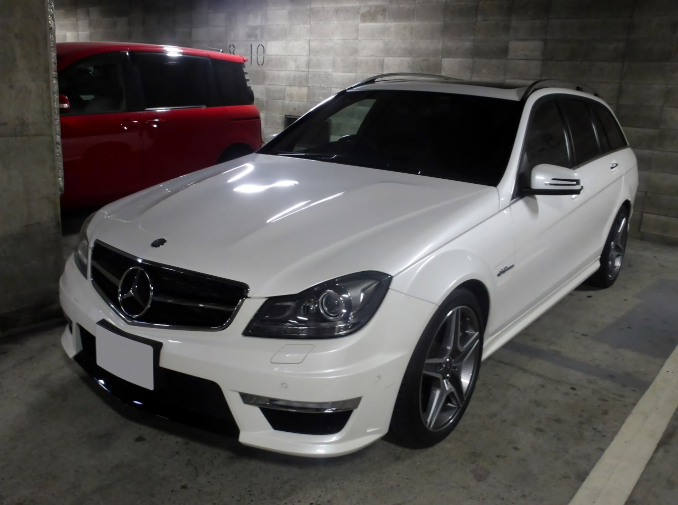Front angled view of a white station wagon with alloy wheels and panoramic roof