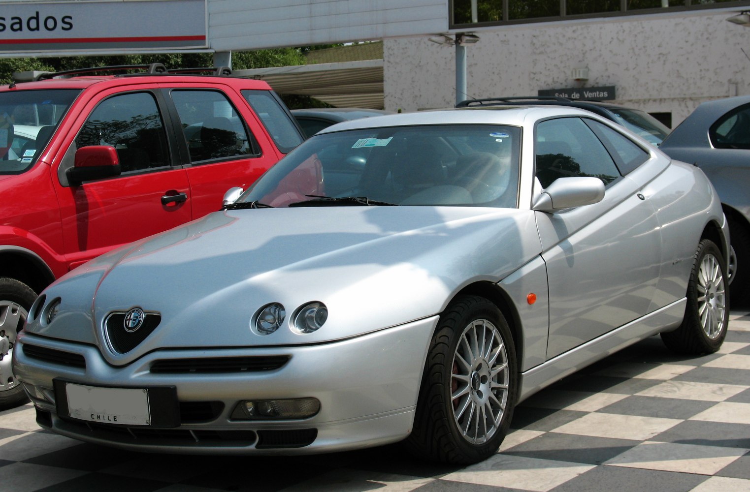 Silver sports coupe with quad round headlights and alloy wheels