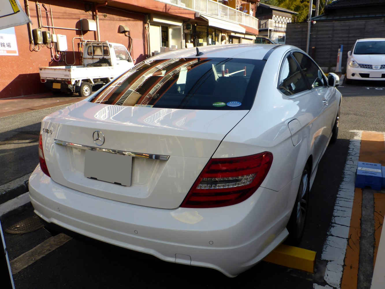 Rear view with taillights and trunk of white luxury coupe