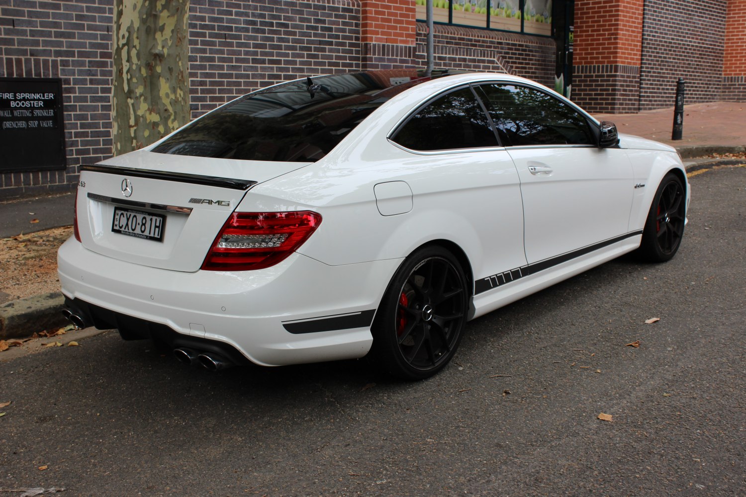 Rear side view of a sleek coupe with AMG styling and black wheels