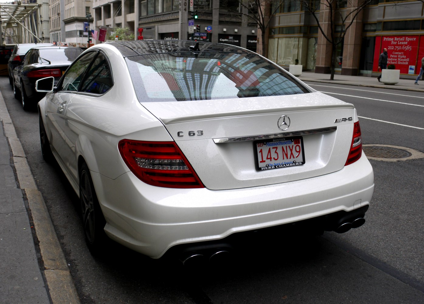Rear view of a white luxury coupe with distinct taillights and AMG badge