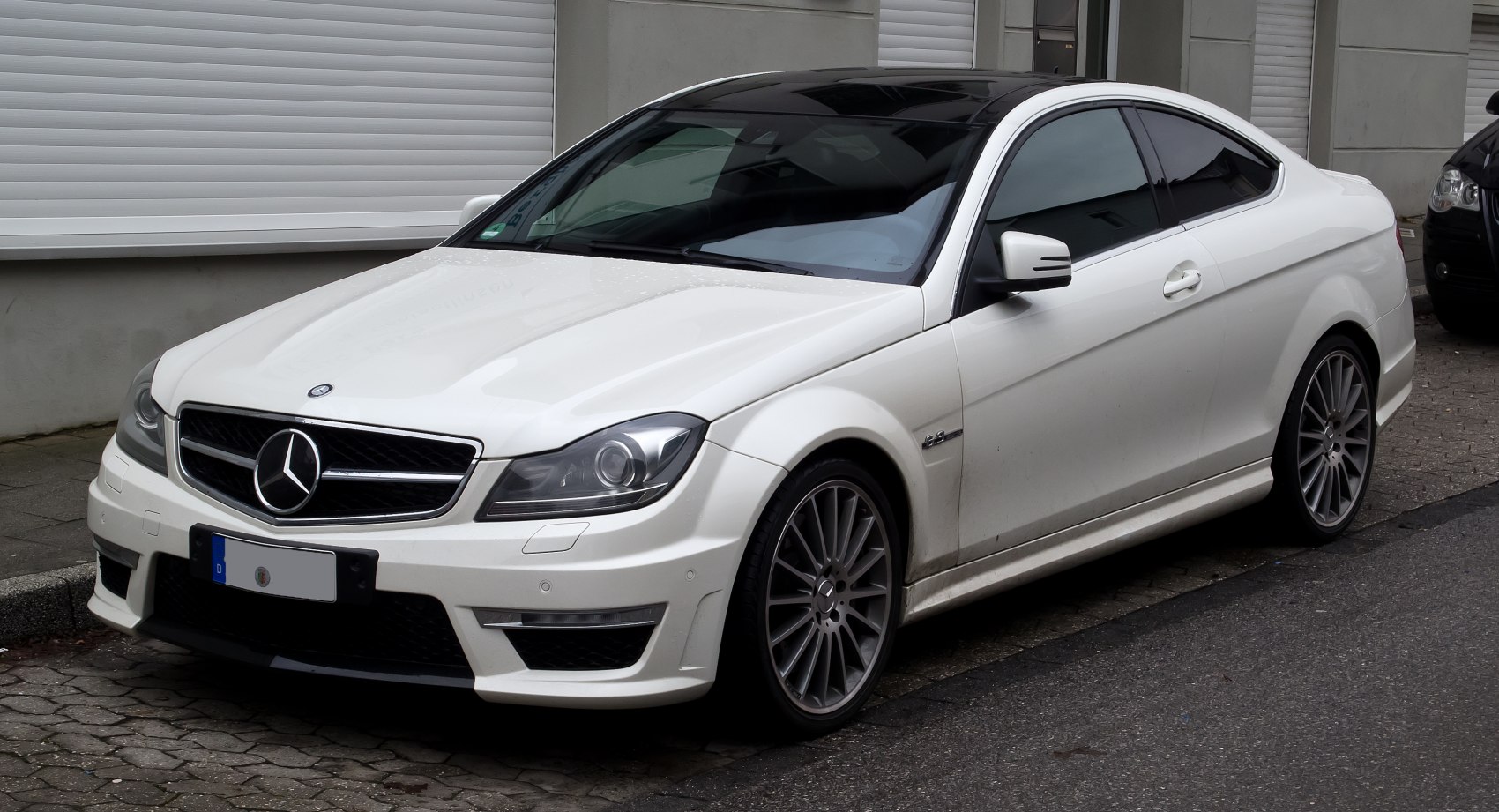 White sporty coupe with sleek design and multi-spoke alloy wheels
