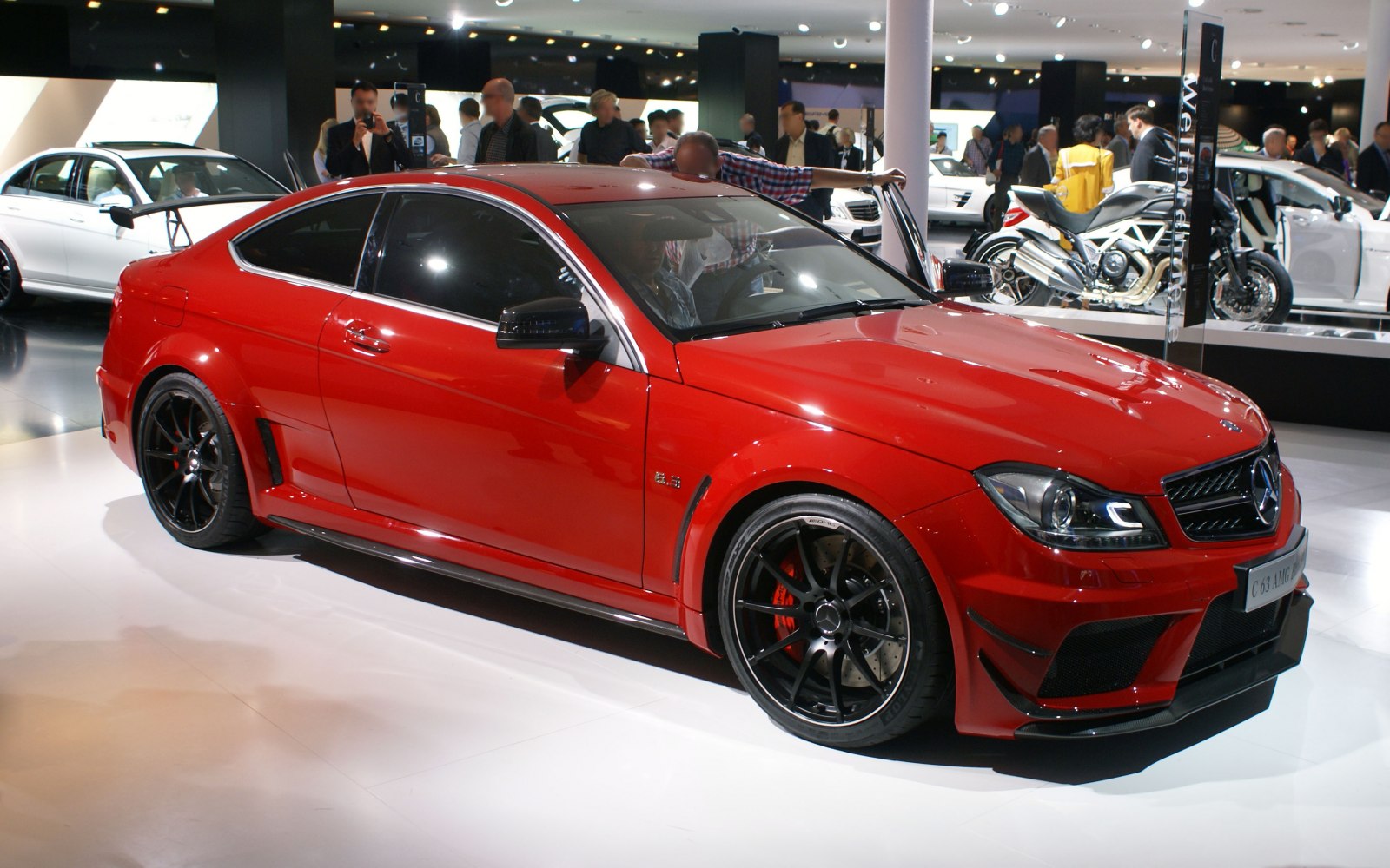 Red coupe with black rims and carbon fiber front splitter