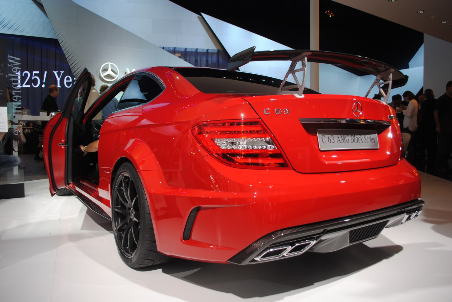 Rear view of red coupe with large carbon spoiler and quad exhausts