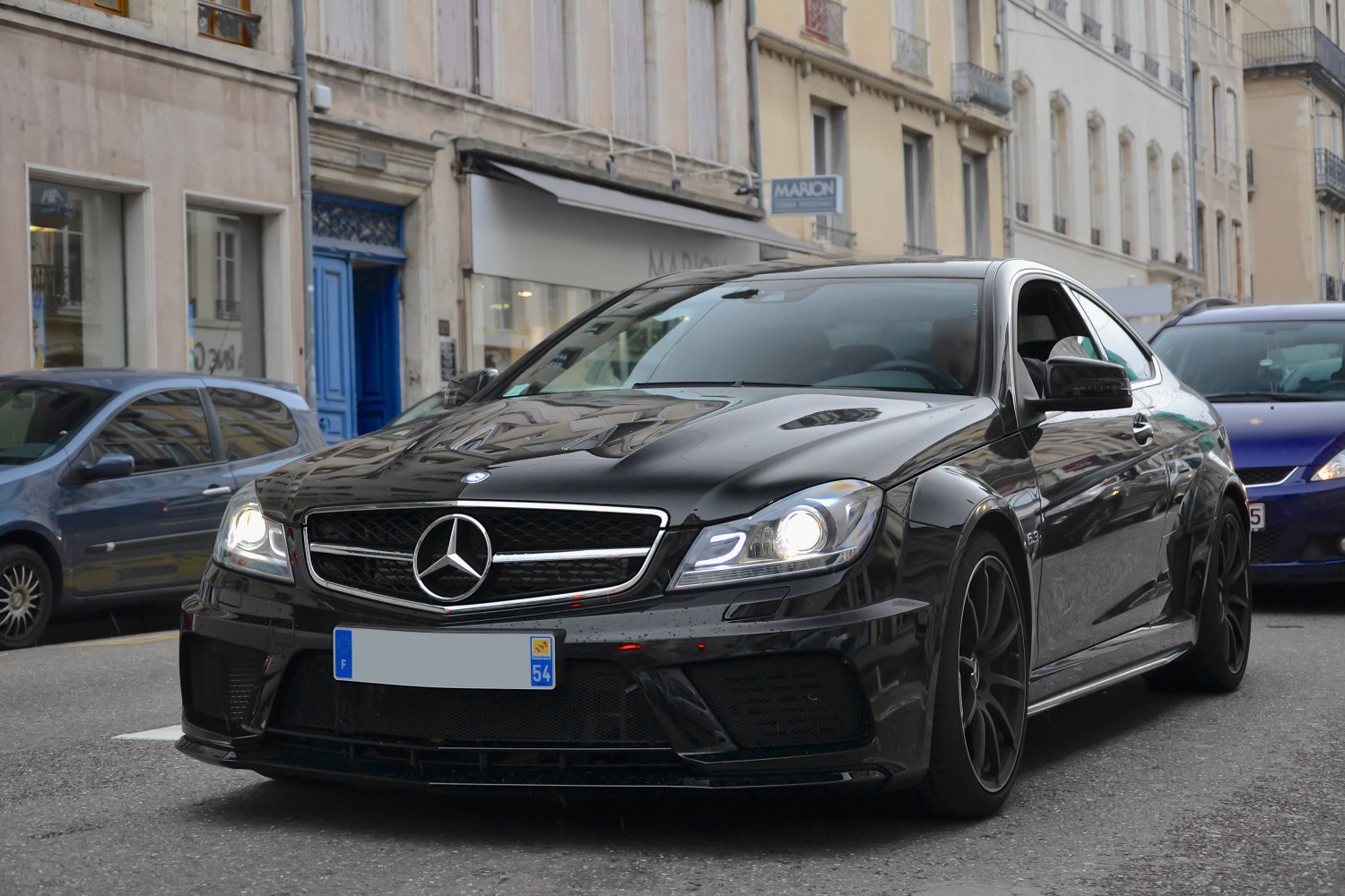 Sporty black coupe with aggressive front grille and LED headlights