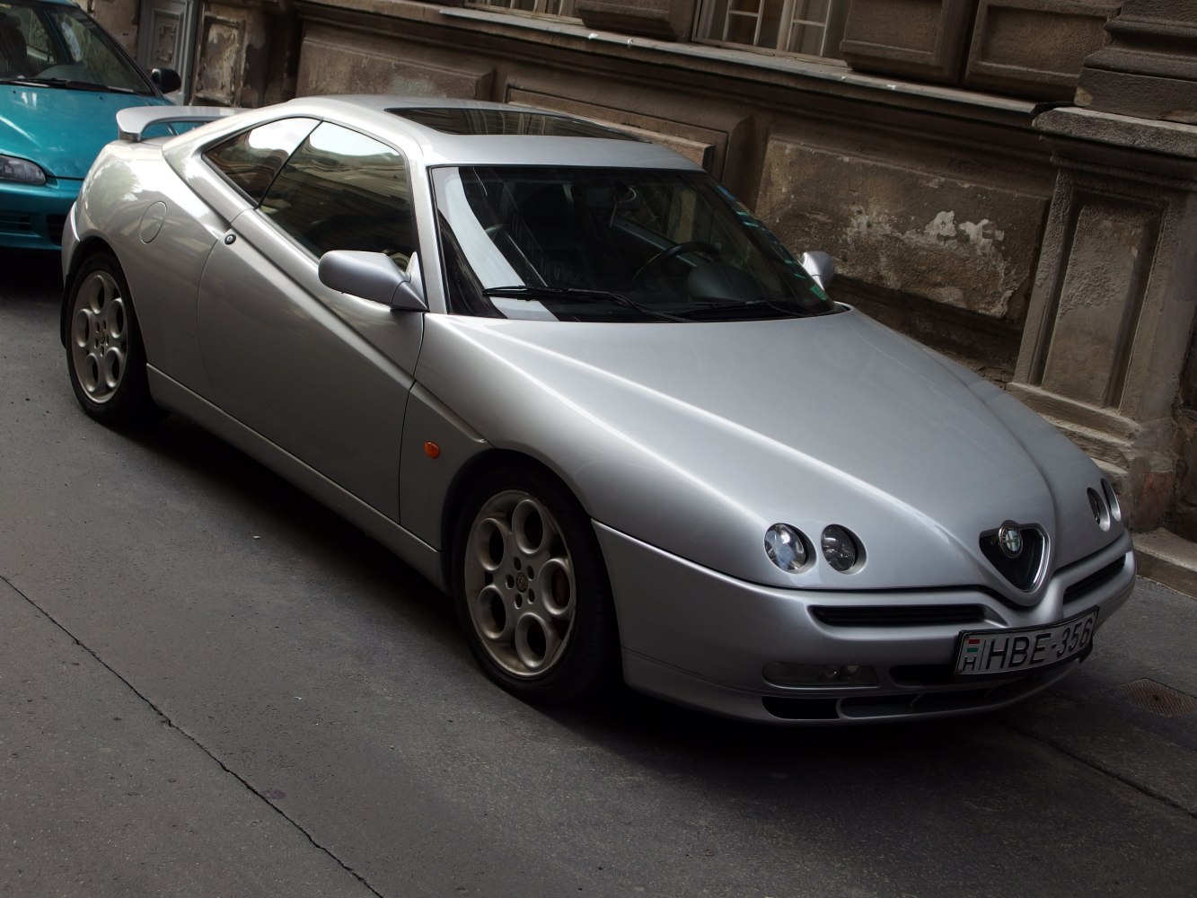 Silver coupe with quad circular front headlamps and aerodynamic body