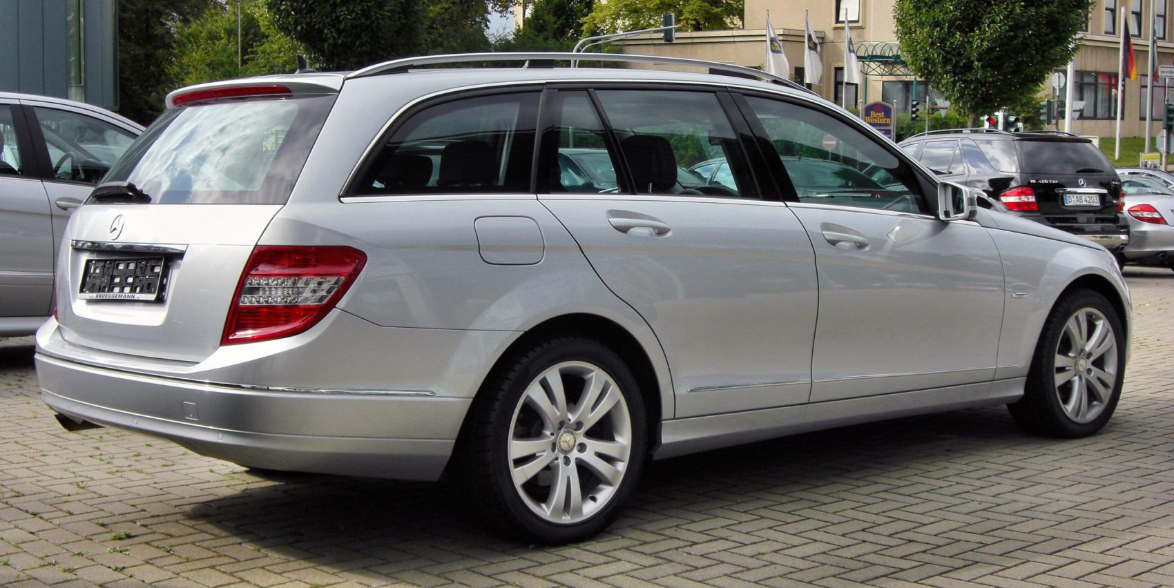 Rear-side view of a silver station wagon with distinctive rear light clusters and roof rails