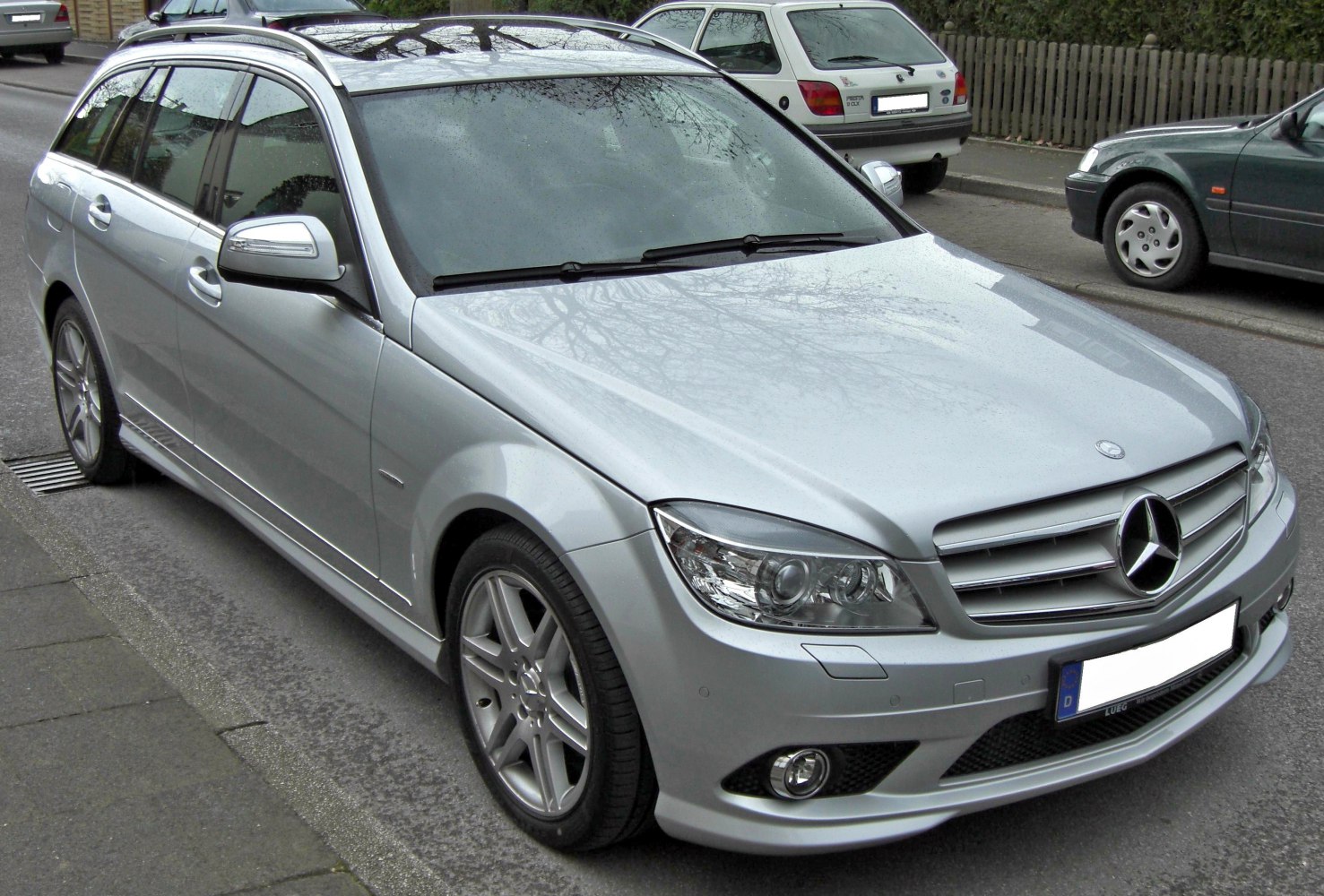 Silver station wagon with alloy wheels, roof rails, and front grille