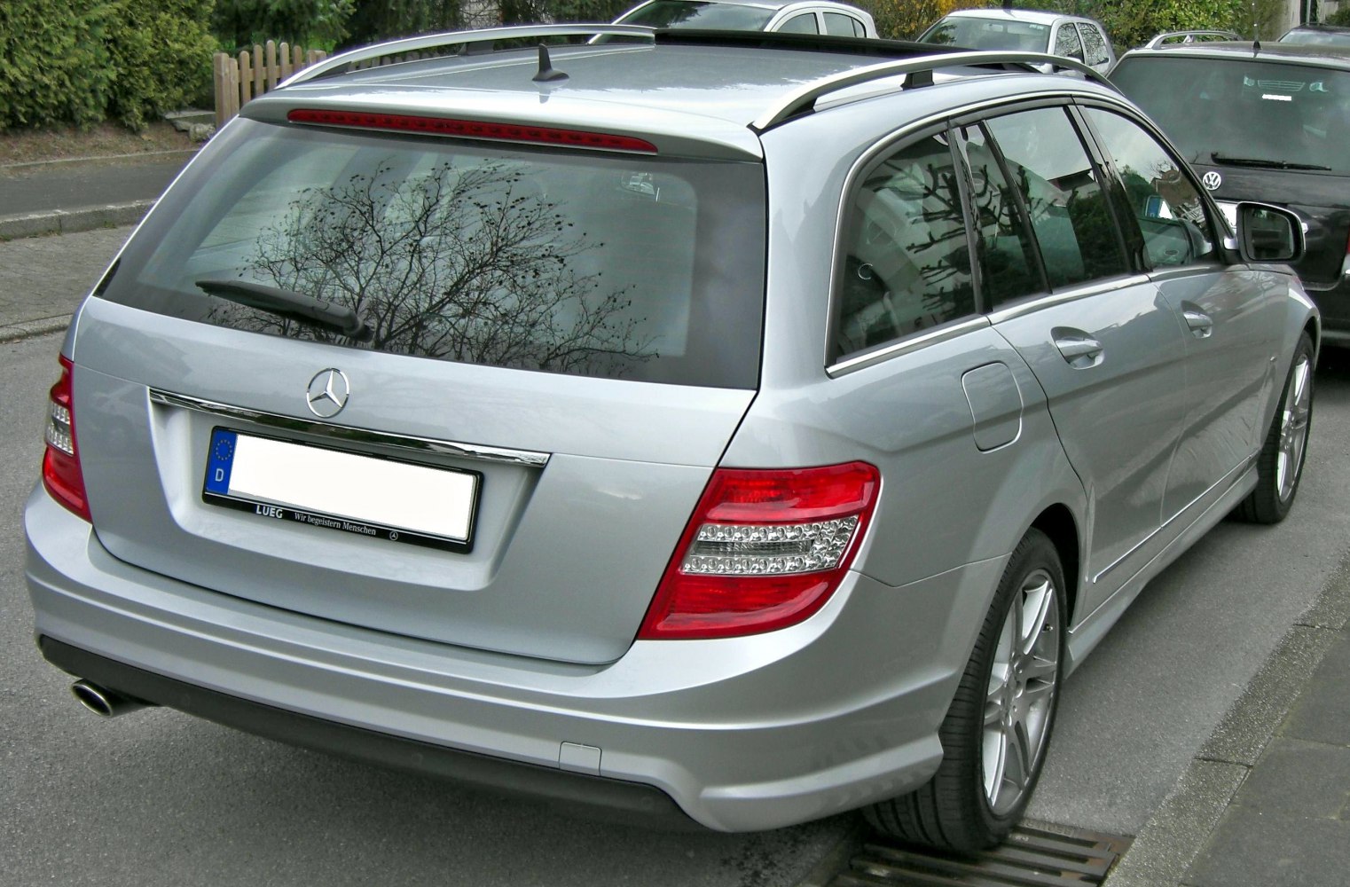 Rear view of silver estate with distinctive tail lights and roof rails