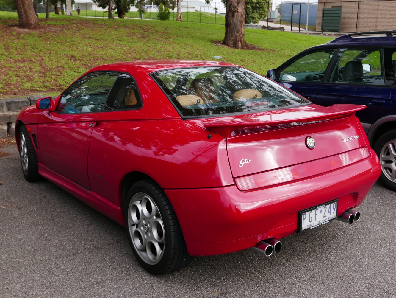 Rear view of red sports coupe with spoiler and dual exhaust