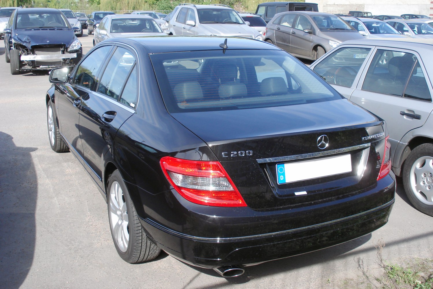 Rear view of a black sedan highlighting taillights and trunk exterior.