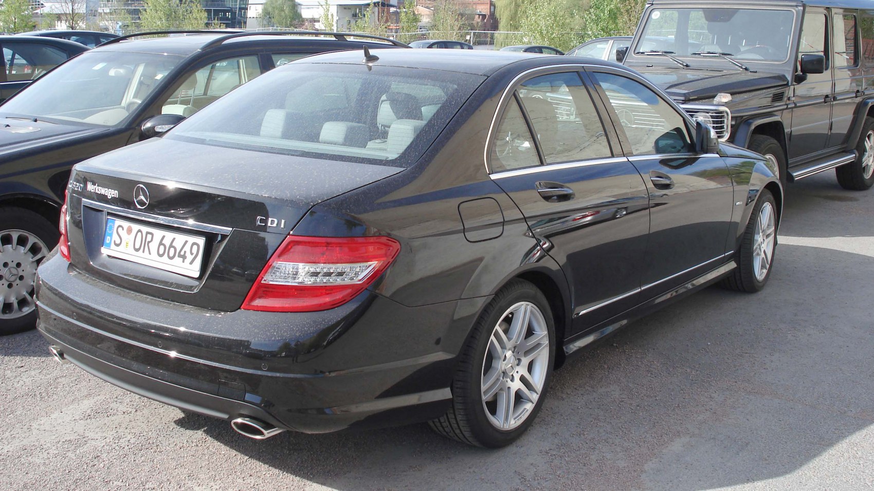 Rear view of sedan with AMG alloy wheels and dual exhaust pipe