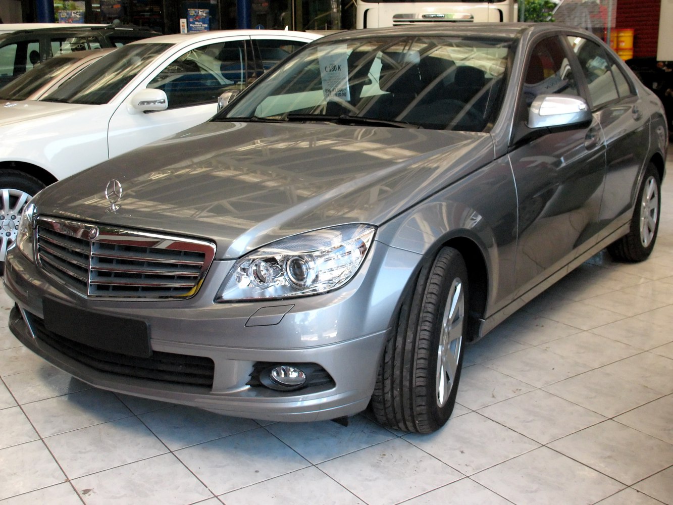 Chrome grille and dual headlights on a gray sedan front