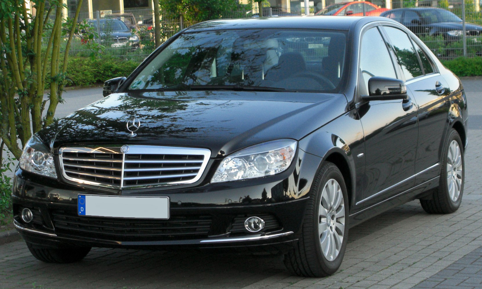 Front-side view of a black sedan with chrome grille and modern headlights