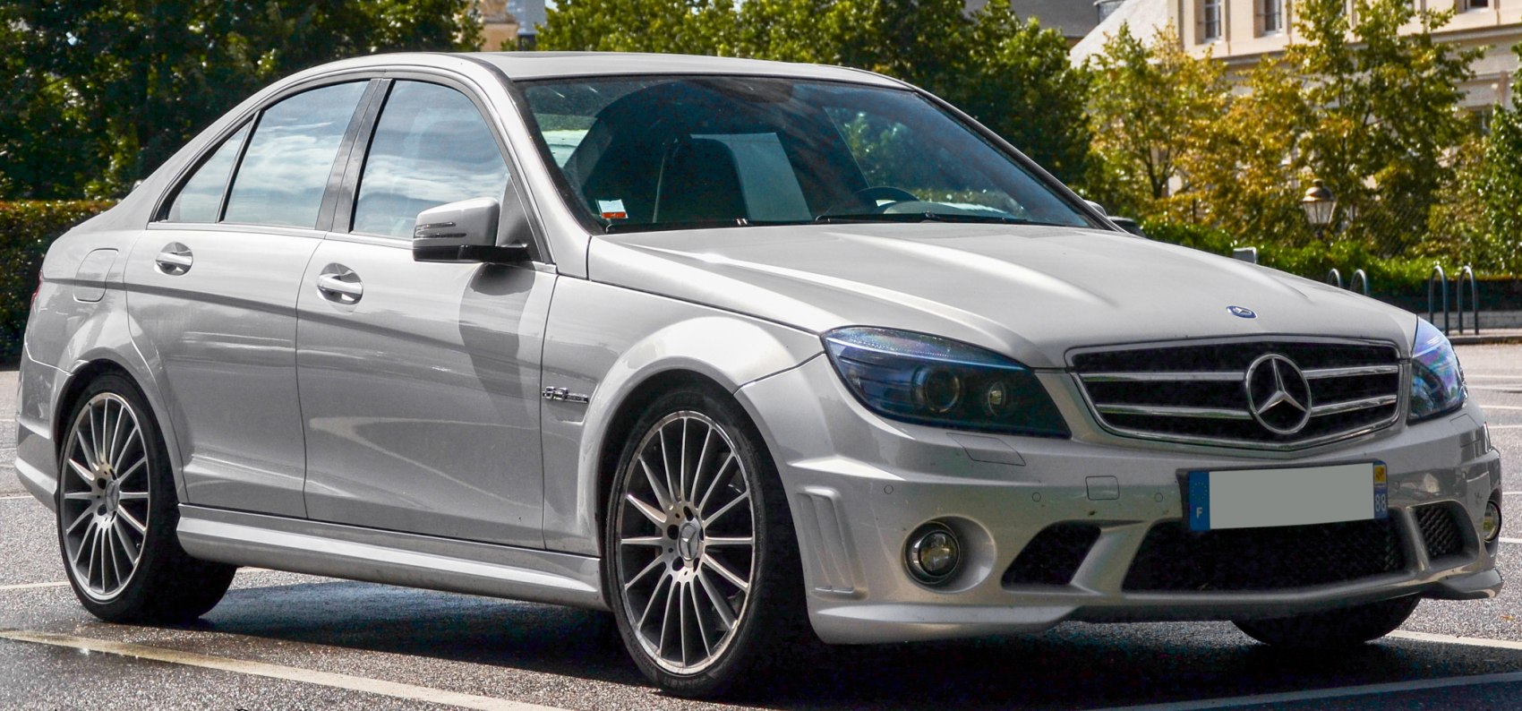 Front angle view of a silver sedan with AMG styling and alloy wheels.