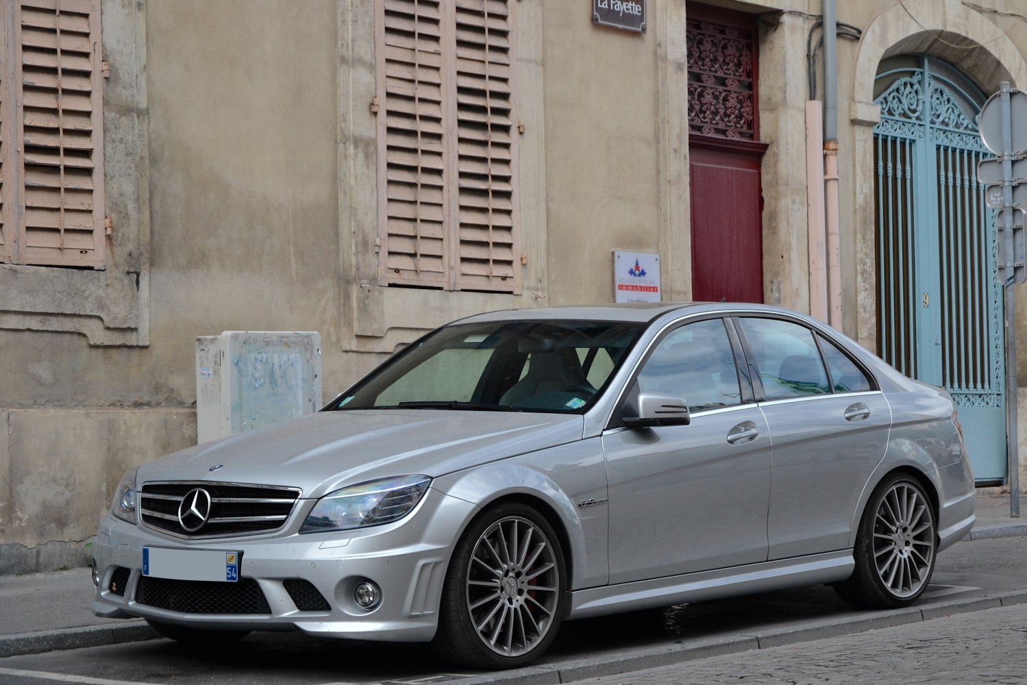 Front side view of silver sedan with sporty AMG wheels