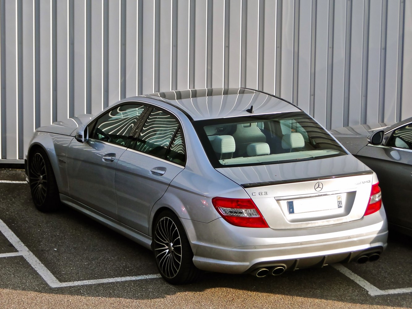 Rear view of luxury sedan with quad exhausts and sporty rear design.
