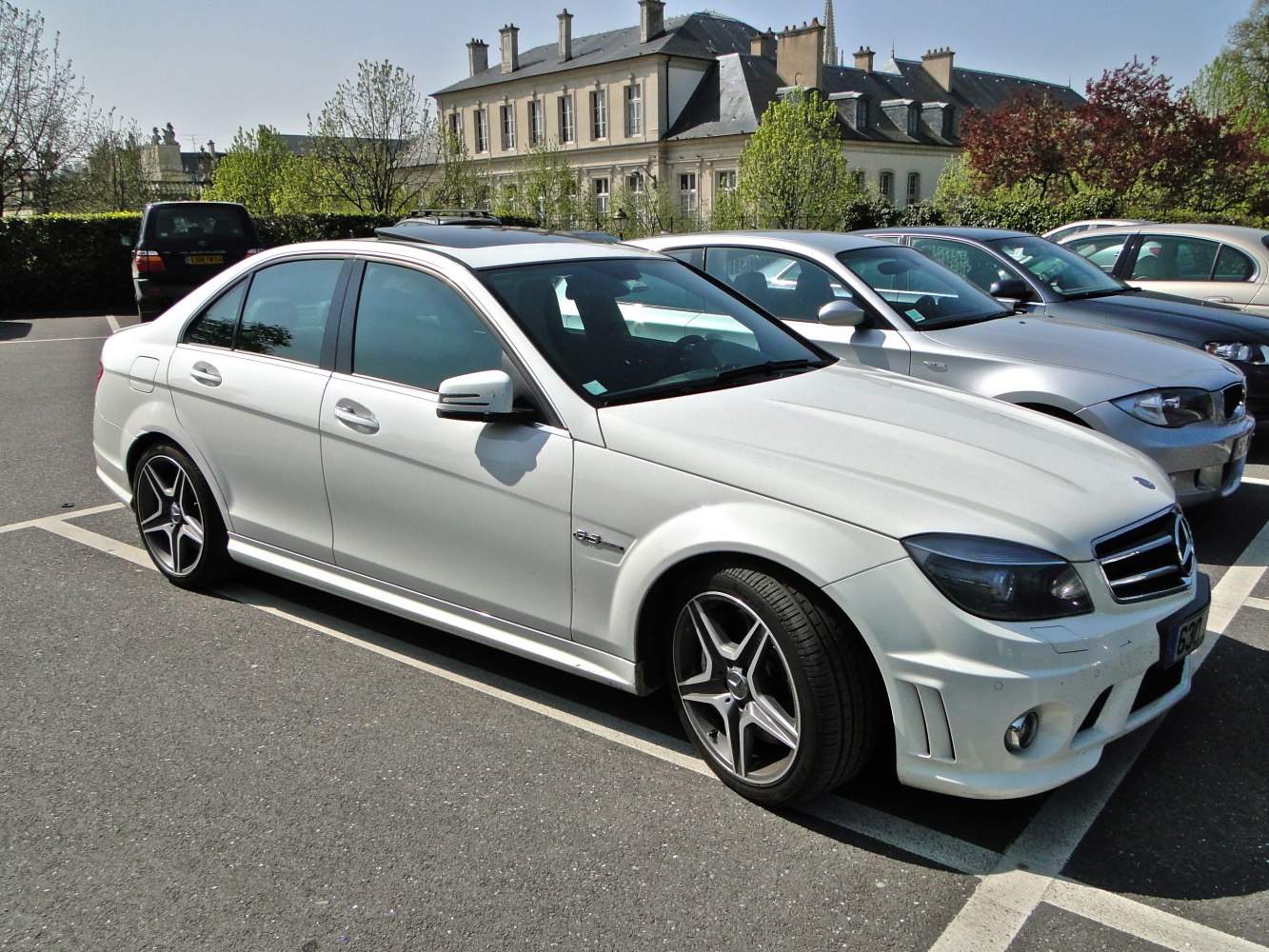 Sporty white sedan with AMG wheels and aggressive front bumper