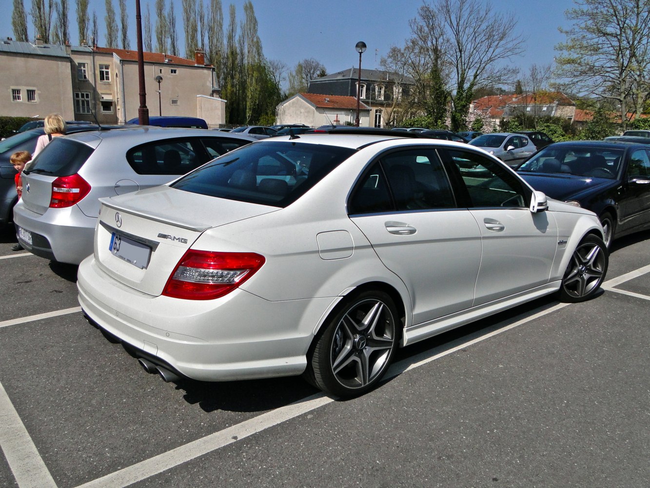 White luxury sedan with AMG wheels and rear spoiler