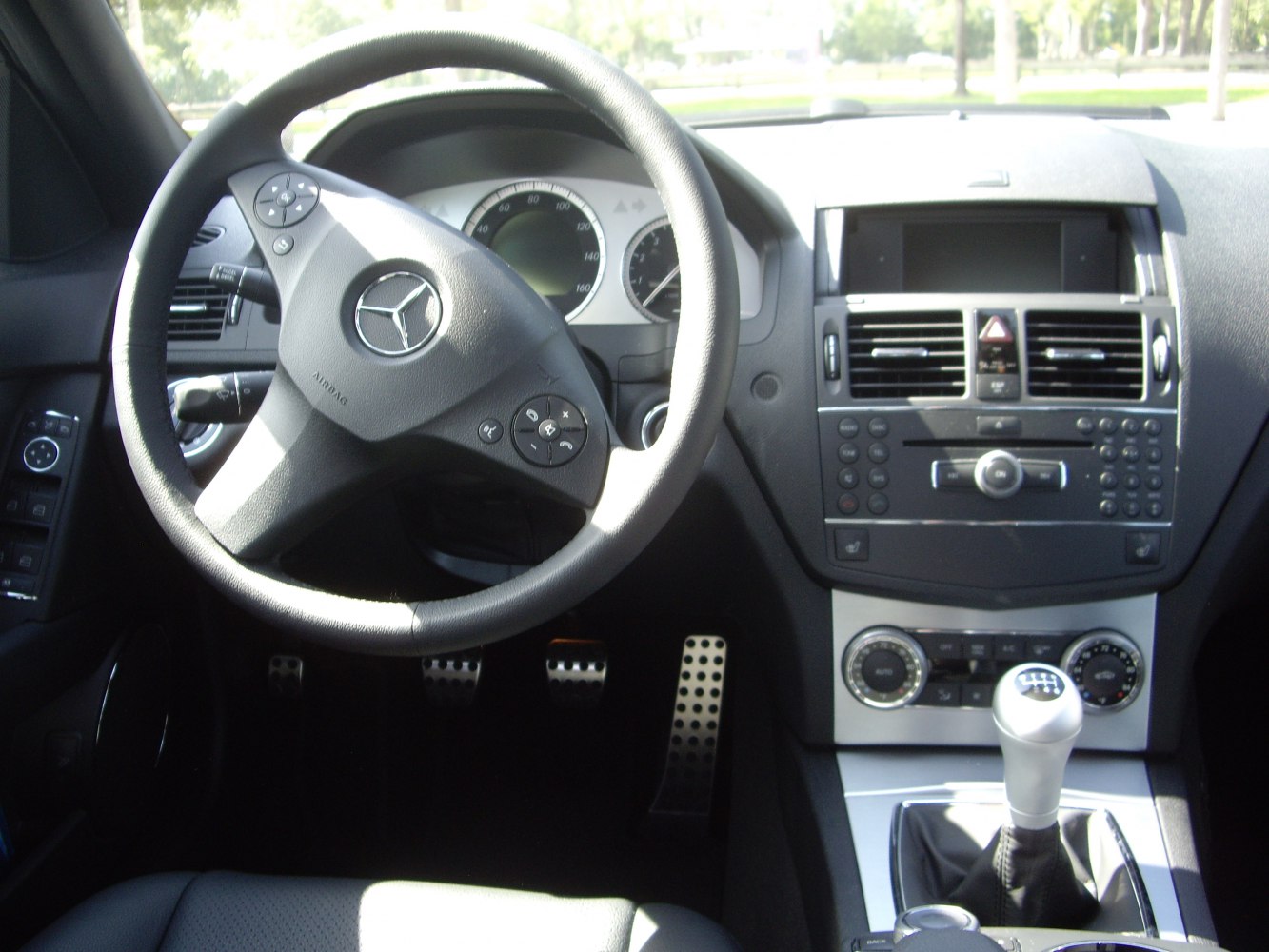 Steering wheel, dashboard, and manual transmission gear stick in car interior
