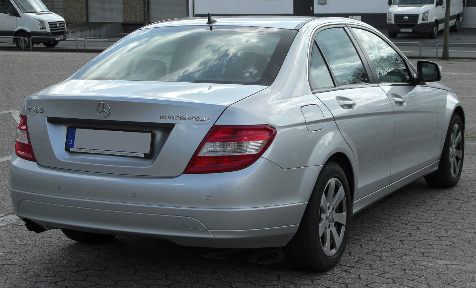 Rear view of a silver sedan with taillights and Kompressor badge