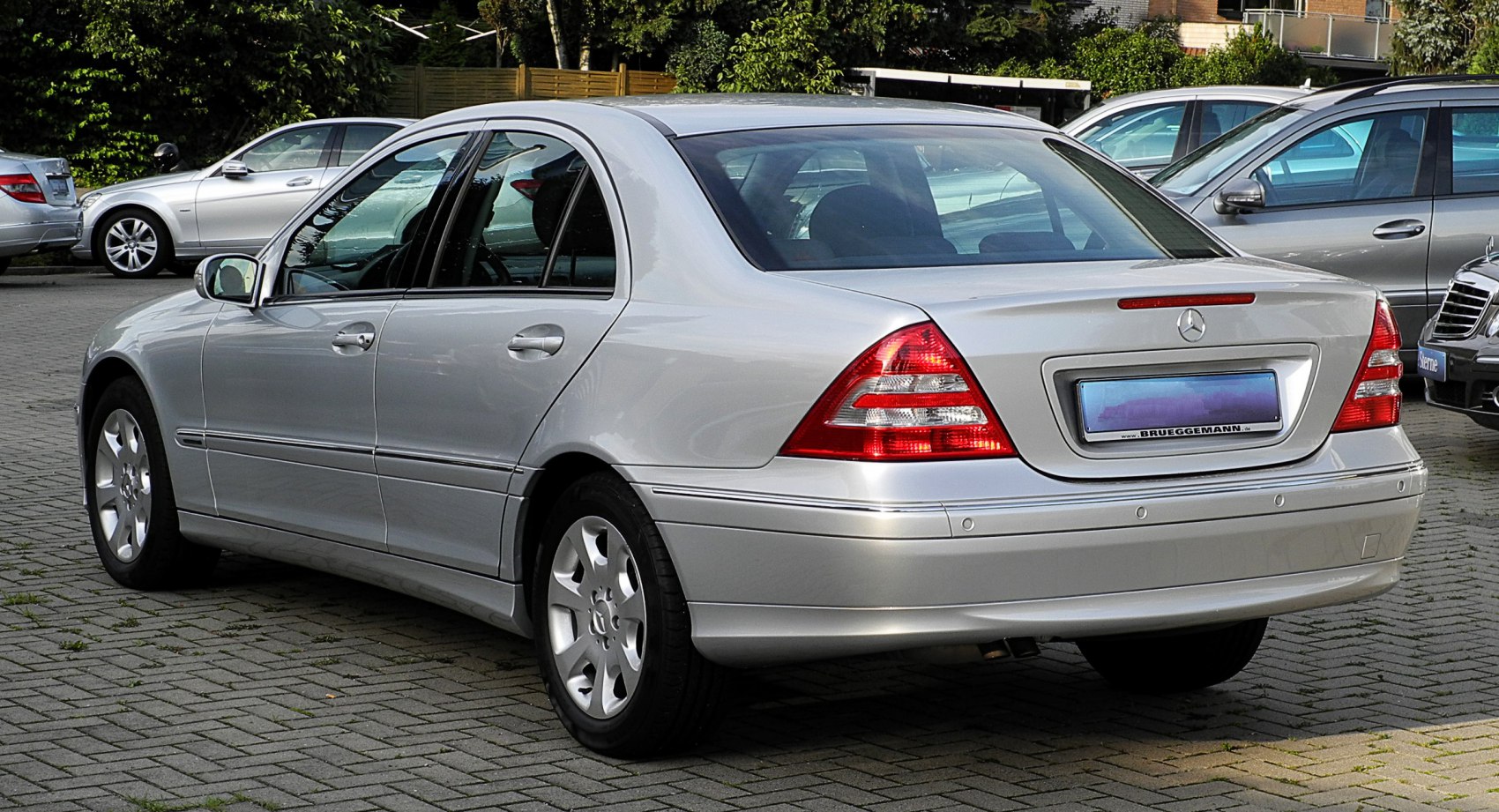 Rear and side view of a silver luxury sedan with distinct taillights.