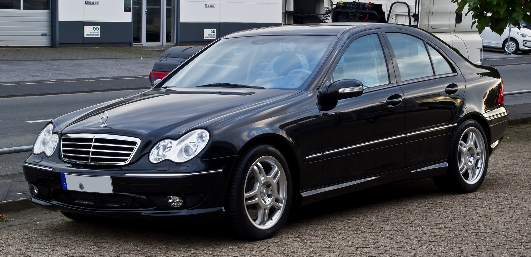 Front and side view of facelift sedan with chrome grille and round headlights