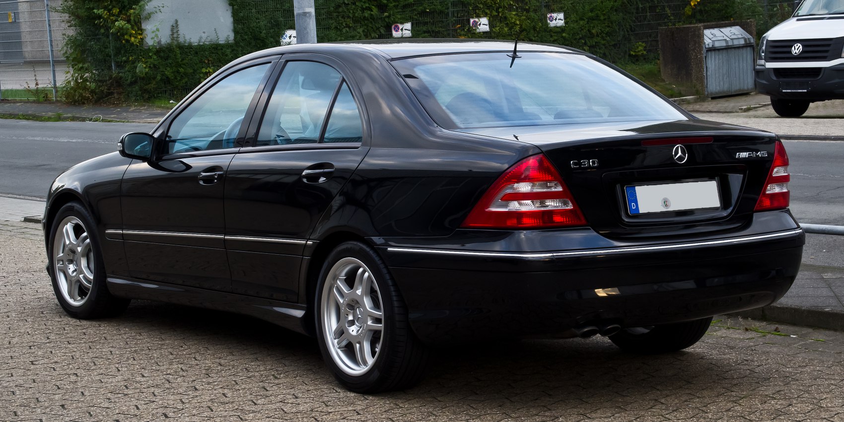 Rear side view of a sedan with distinctive taillights and AMG alloy wheels.